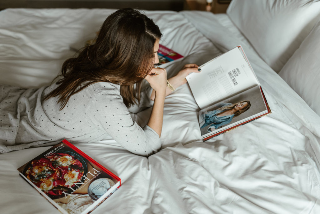 genevieve padalecki of now&gen wife of jared padalecki of supernatural lies on bed with cookbooks reading a cookbook